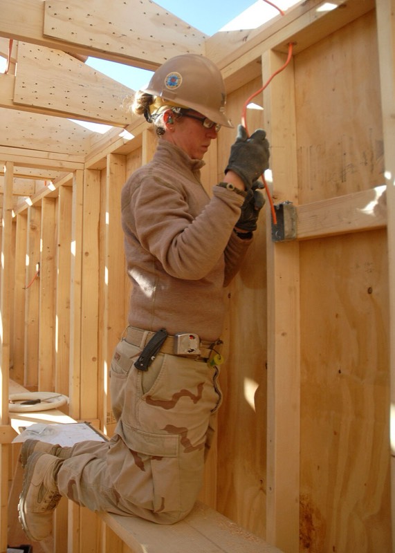 An electrician at work in a timber frame