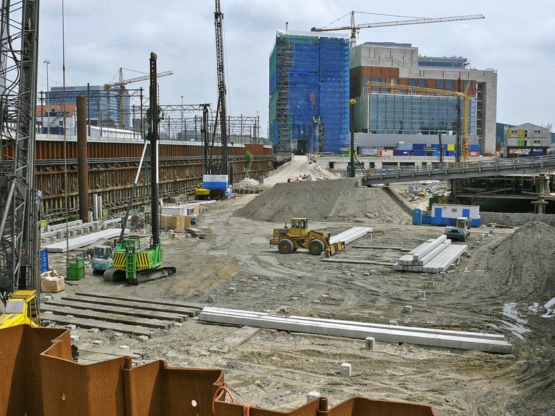 A large excavation site with cranes and new buildings
